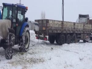 Karda ilerleyemeyen tırların imdadına traktörler yetişiyor